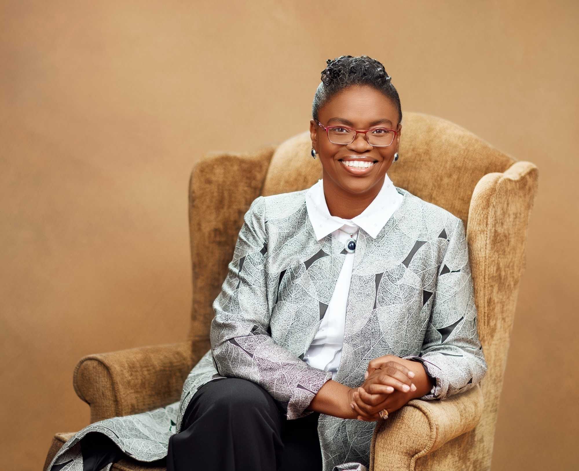 Prof. Toyin Tofade seated in a brown armchair